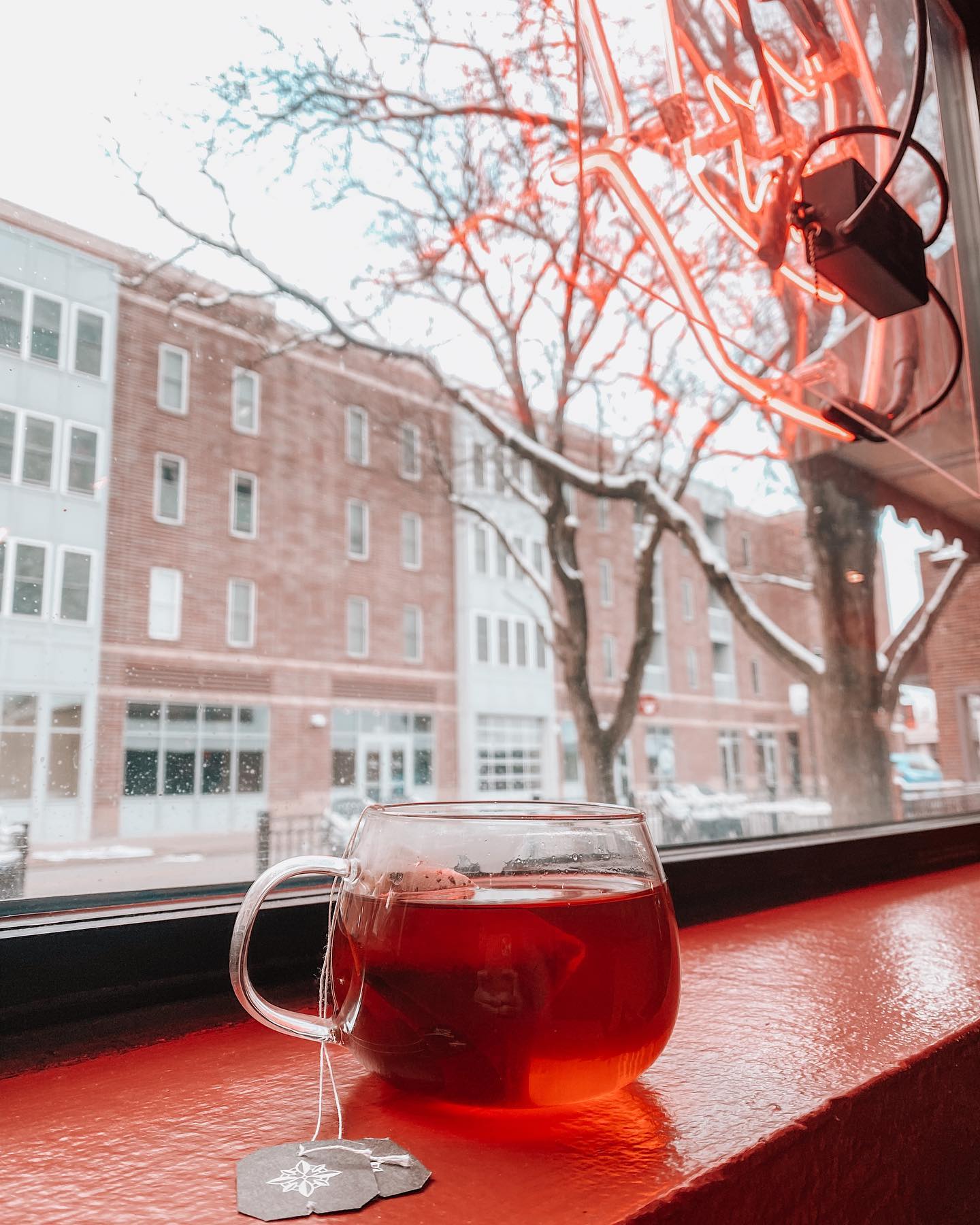 Hot tea by the window with neon Open sign