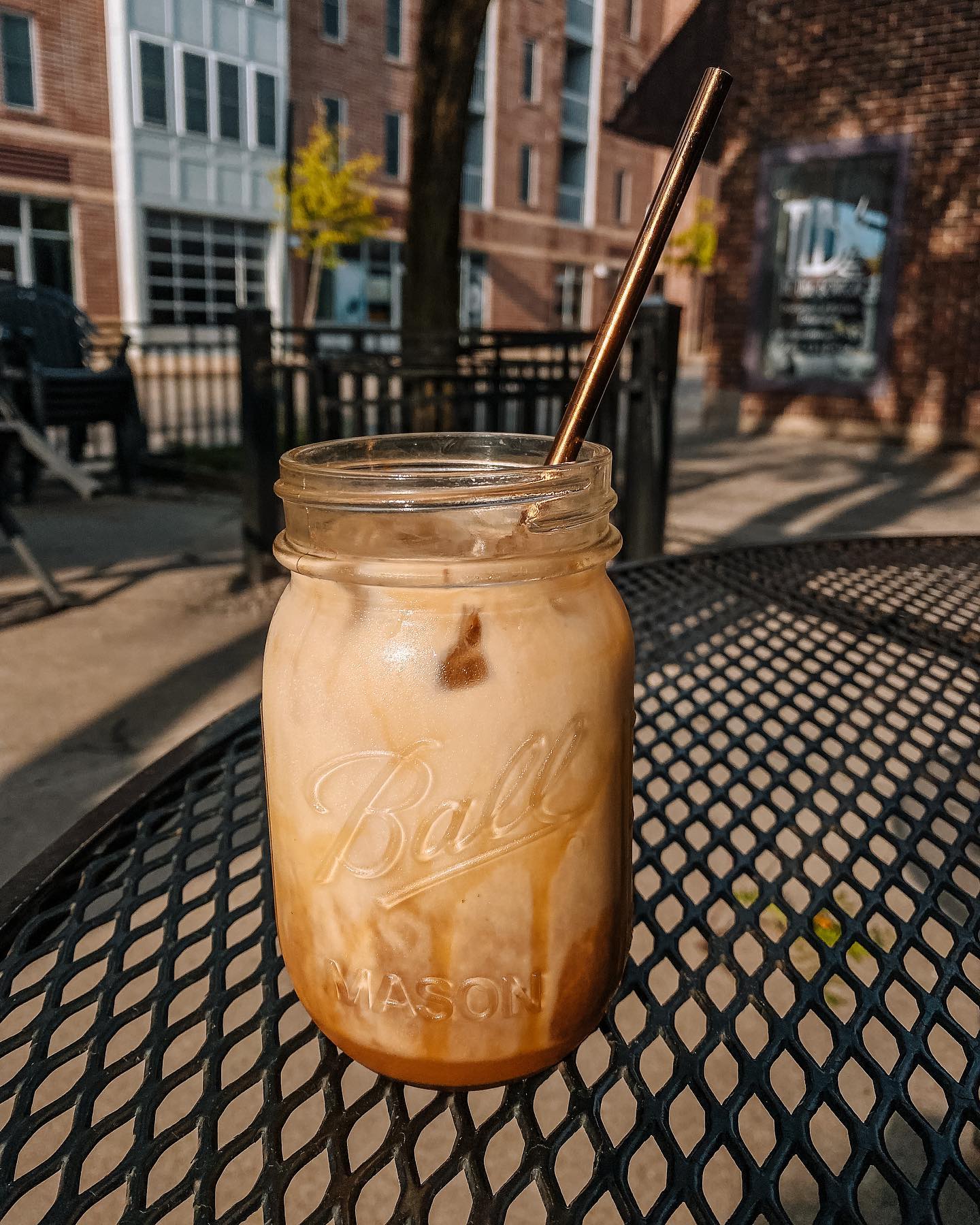 Iced latte in a Ball mason jar on patio